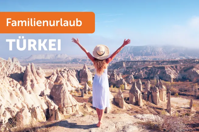 Frau steht auf einem Berg mit weiter Aussicht