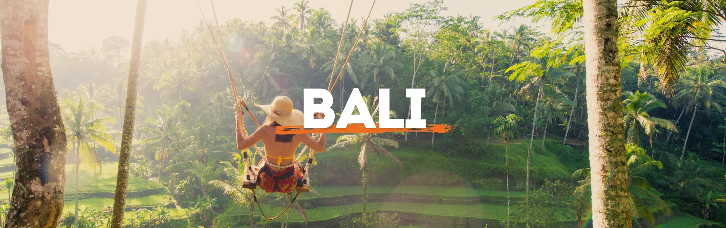 Frau mit Hut schaukelt über Reisplantagen auf Bali