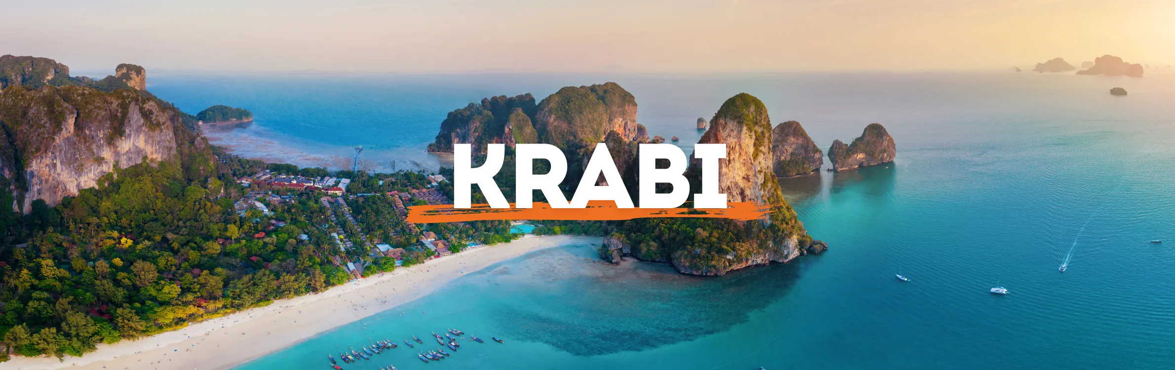 Strand von Krabi mit steilen Klippen und kleinen Häusern