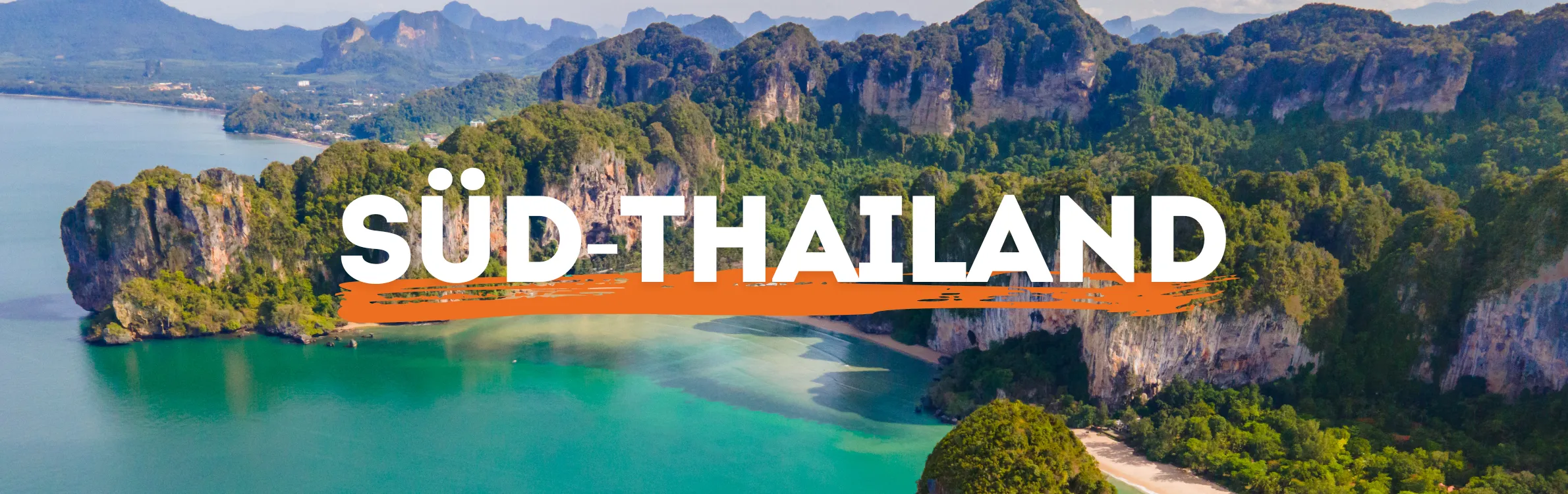 Ein kleines Boot am Strand in Thailand mit einer Klippe im Hintergrund