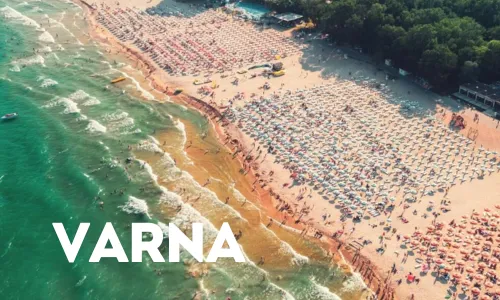 Strand von oben gesehen mit vielen Sonnenschirmen und vielen Menschen