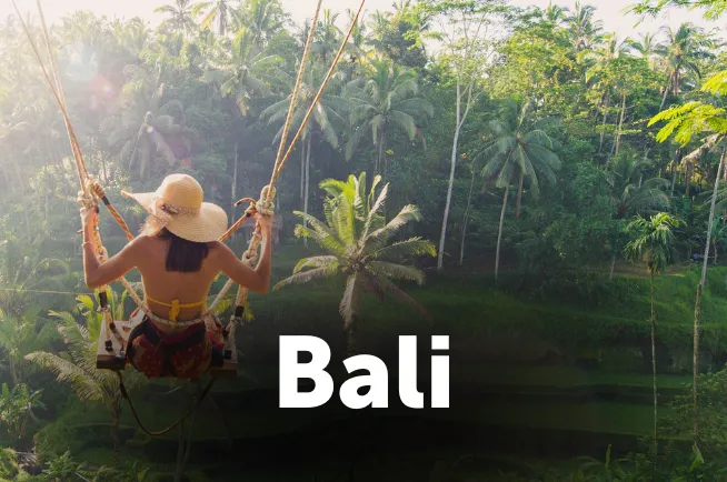 Eine Frau mit Hut auf einer Schaukel auf Bali